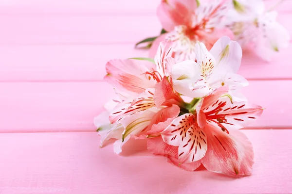 Schöne Alstroemeria-Blumen auf Holztisch — Stockfoto