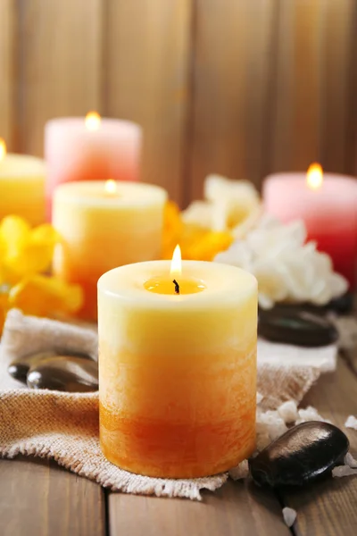 Beautiful candles with flowers on wooden background — Stock Photo, Image