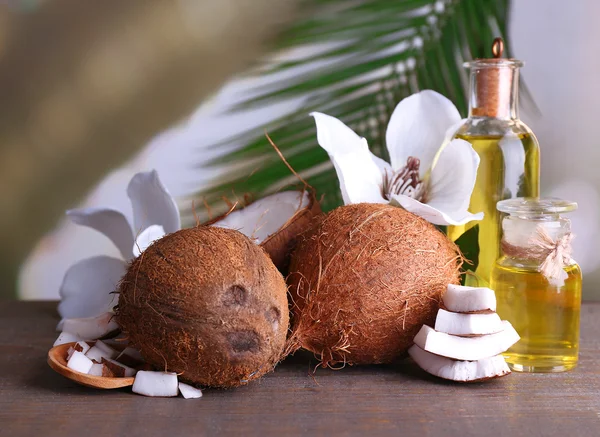 Кокосы и кокосовое масло на деревянном столе — стоковое фото