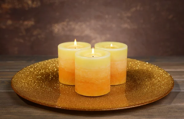 Beautiful candles on table on brown background — Stock Photo, Image