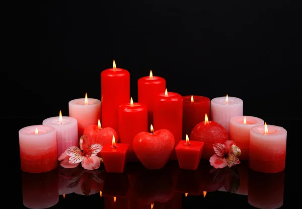 Hermosas velas con flores aisladas en negro —  Fotos de Stock