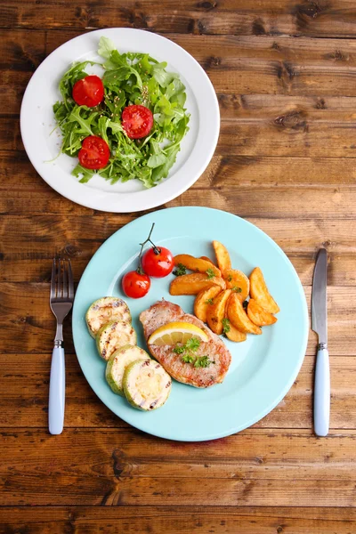 Grilovaný steak, grilovaná zelenina a svěží zelený salát na pozadí tabulky — Stock fotografie