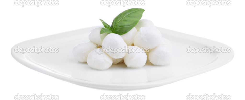 Tasty mozzarella cheese with basil on plate isolated on white
