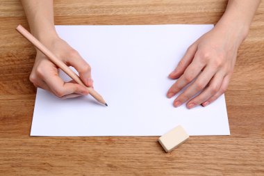 insan eli kalem kağıt ve erase kauçuk ahşap masa arka plan üzerinde yazma ile