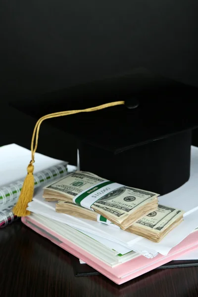 Χρήματα για την αποφοίτηση ή κατάρτισης σχετικά με ξύλινο τραπέζι σε γκρι φόντο — Φωτογραφία Αρχείου