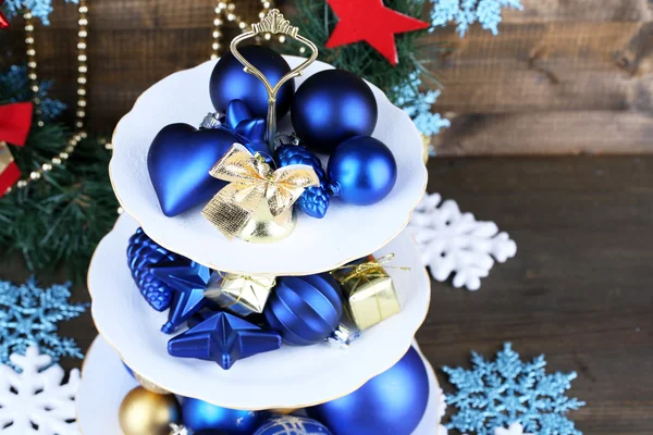 Christmas decorations on dessert stand, on  color wooden background — Stock Photo, Image