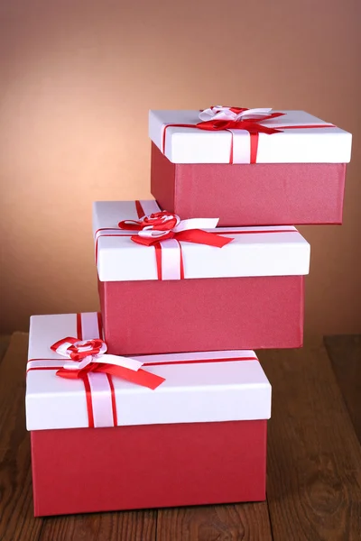 Belas caixas de presente na mesa no fundo marrom — Fotografia de Stock