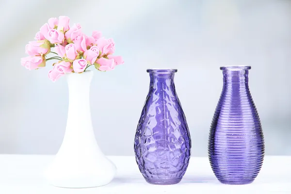 Diferentes vasos decorativos na prateleira no fundo claro — Fotografia de Stock