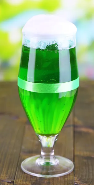 Copo de cerveja verde para o dia de St. Patricks na mesa de madeira no fundo natural — Fotografia de Stock