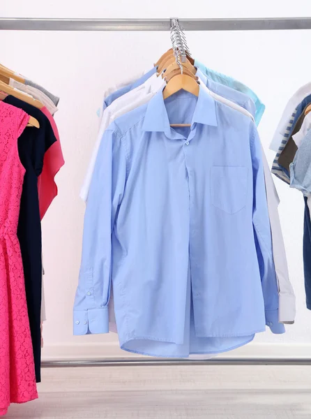 Verschillende kleding op hangers, op grijze achtergrond — Stockfoto