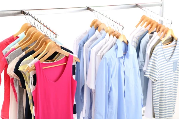 Different clothes on hangers, on gray background — Stock Photo, Image