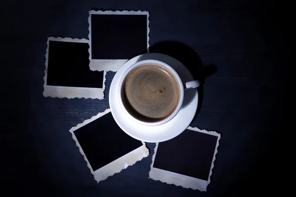 Xícara de café e velhas fotos em branco, no fundo de madeira — Fotografia de Stock