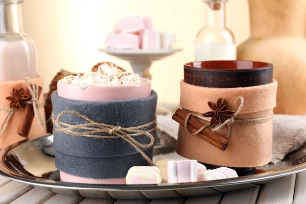 Mug of hot drink decorated in felt on wooden table