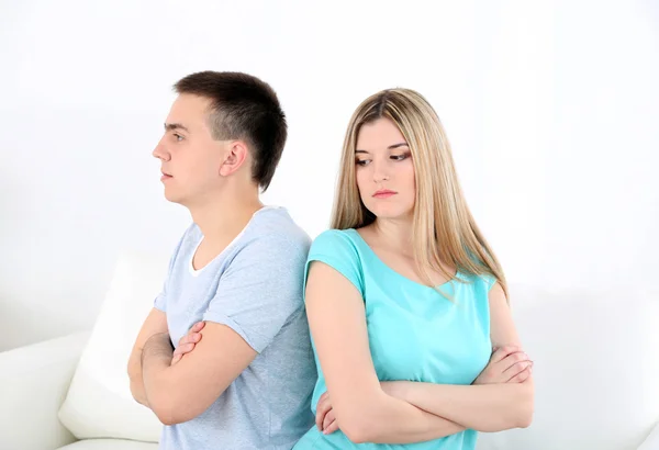 Jeune homme et femme conflit assis sur le canapé discuter malheureux, sur le fond intérieur de la maison — Photo