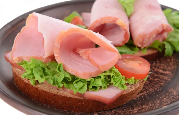 Marul ve plaka yakın çekim jambon ile lezzetli sandviçler — Stok fotoğraf