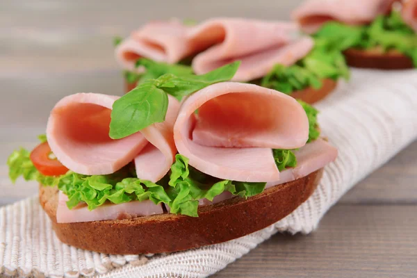 Deliziosi panini con lattuga e prosciutto in tavola primo piano — Foto Stock