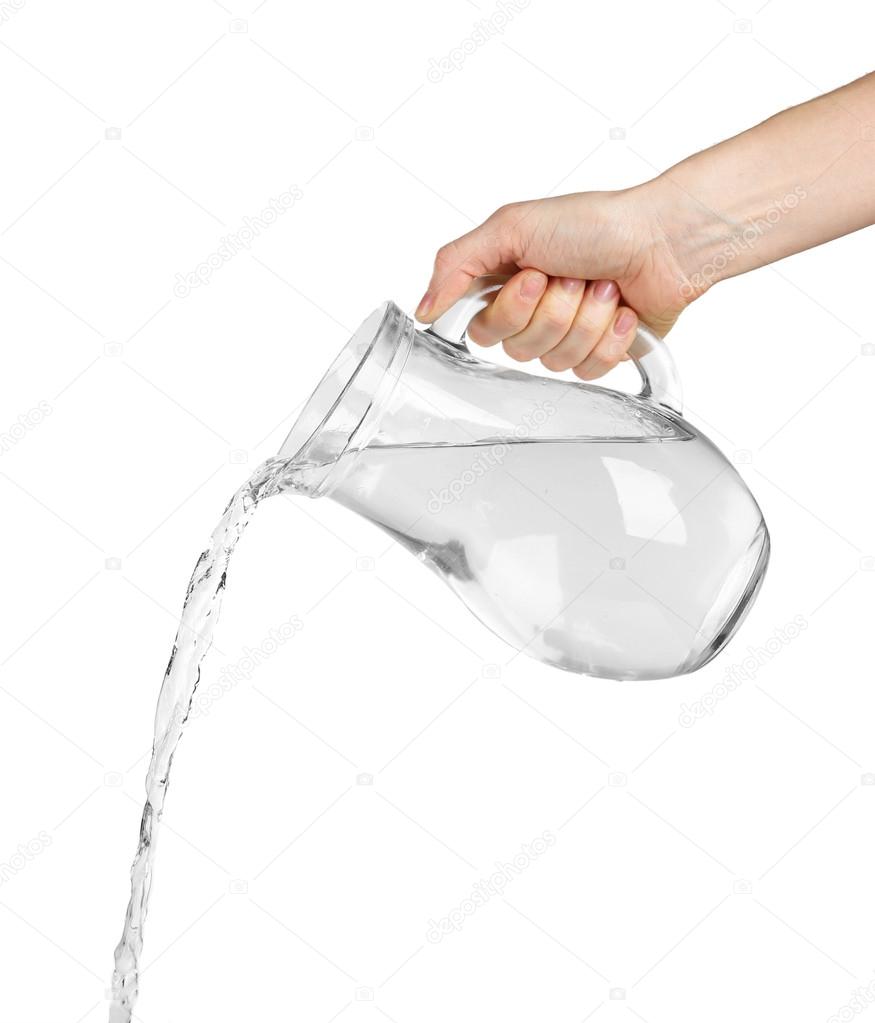 Pouring water from glass pitcher, isolated on white