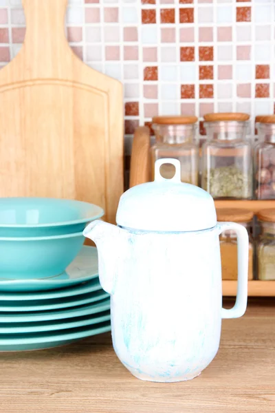 Tableware in kitchen on table on mosaic tiles background — Stock Photo, Image