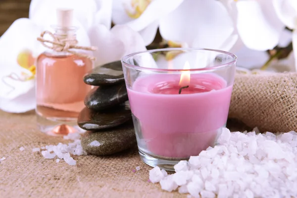 Composition with beautiful colorful candles, sea salt and orchid flowers, on wooden background — Stock Photo, Image