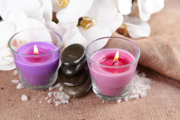 Composizione con belle candele colorate, sale marino e fiori di orchidea, su sfondo di legno — Foto Stock