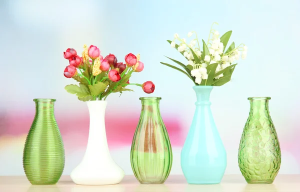 Olika dekorativa vaser på hyllan på ljus bakgrund — Stockfoto