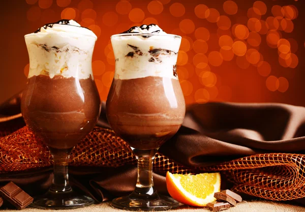 Dessert savoureux avec chocolat, crème et sauce orange, sur la table, sur fond clair — Photo