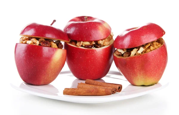Яблука з родзинками і горіхами на тарілці ізольовані на білому — стокове фото