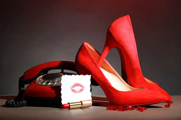 Beautiful red female shoes and retro telephone, on grey background — Stock Photo, Image