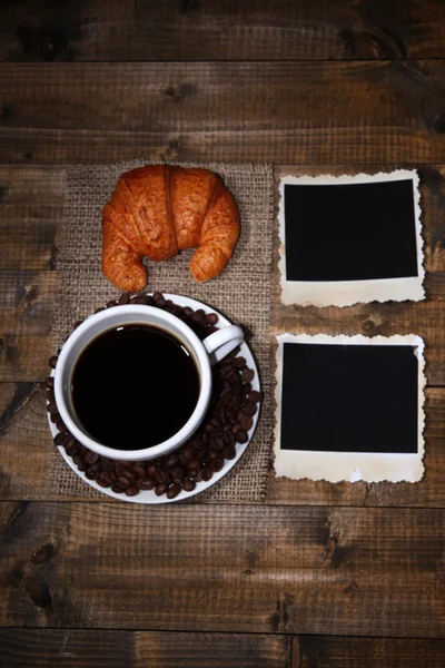 Taza de café, bollo y fotos viejas en blanco, sobre fondo de madera — Foto de Stock