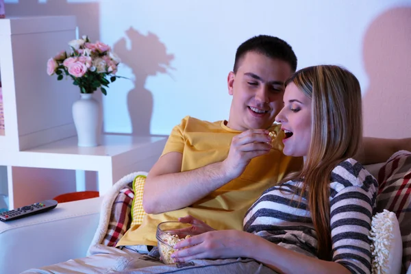 Junges Paar schaut bei Verdunkelung zu Hause fern — Stockfoto