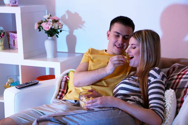 Junges Paar schaut bei Verdunkelung zu Hause fern — Stockfoto