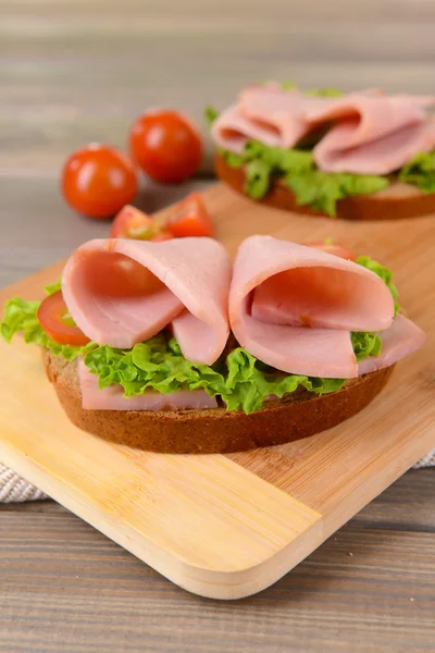 Deliciosos sándwiches con lechuga y jamón en primer plano — Foto de Stock