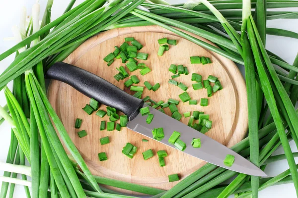 Cebolla verde en una tabla de cortar con cuchillo de cerca — Foto de Stock