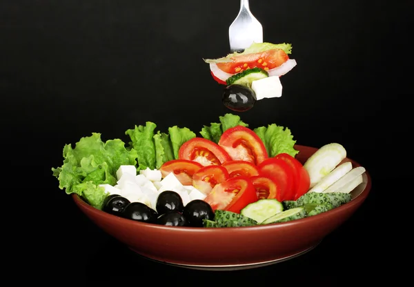 Välsmakande grekisk sallad på svart bakgrund närbild — Stockfoto