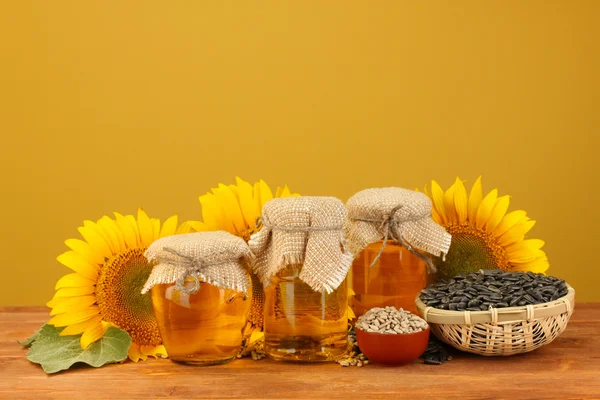 Sunflower oil and sunflower on yellow background — Stock Photo, Image