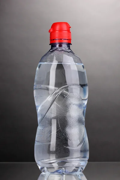 Plastic bottle of water on grey background — Stock Photo, Image