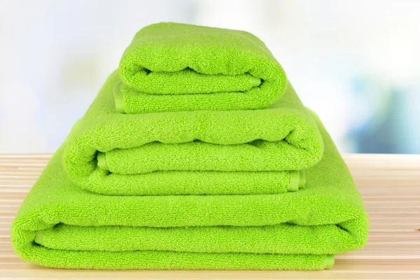 Green towels on table on light background — Stock Photo, Image