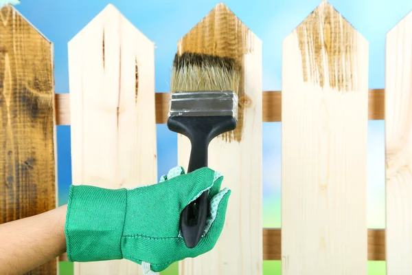 Védőlakk alkalmazása a fából készült kerítésen, fényes háttérrel — Stock Fotó