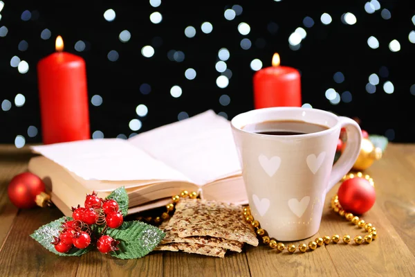 本书带杯咖啡和圣诞装饰品上深色背景表格的组成 — 图库照片
