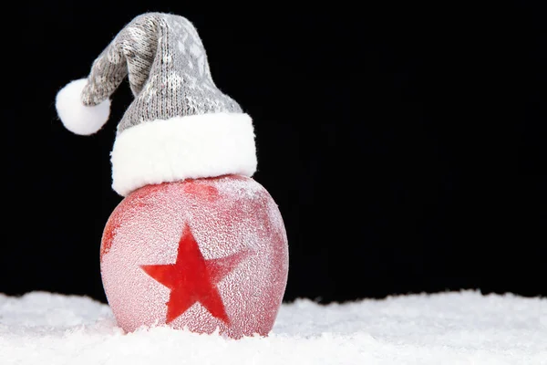 Maçã de férias com estrela fosca na neve no fundo preto — Fotografia de Stock