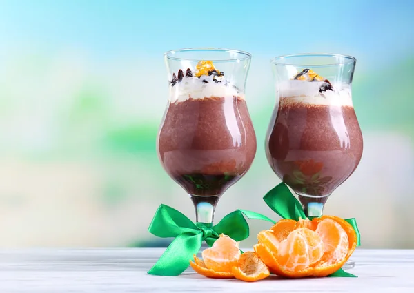 Sobremesa saborosa com chocolate, creme e molho de laranja, em guardanapo. na mesa de madeira, no fundo claro — Fotografia de Stock