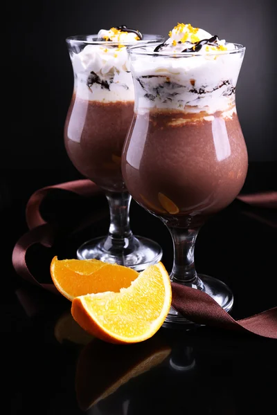 Tasty dessert with chocolate, cream and orange sauce, on dark color background — Stock Photo, Image