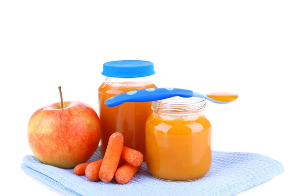 Baby food with carrot and apple in glass jars, isolated on white Royalty Free Stock Images