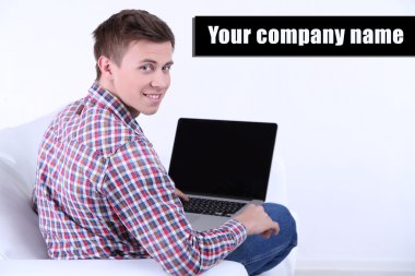 dizüstü bilgisayar ile kanepede oturan adamı