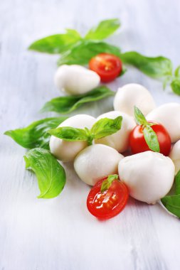 ahşap masa üstünde domates ve fesleğen ile lezzetli mozzarella peyniri