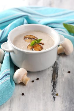 peçeteye ahşap arka plan üzerinde beyaz tencerede mantar çorbası