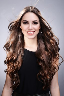 gri zemin üzerine uzun saçlı güzel bir genç kadın