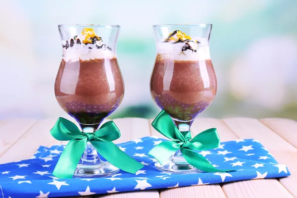 Leckeres Dessert mit Schokolade, Sahne und Orangensoße auf Serviette. auf Holztisch, auf hellem Hintergrund — Stockfoto