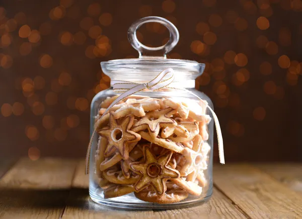 Deliciosas galletas de Navidad en tarro sobre mesa sobre fondo marrón —  Fotos de Stock