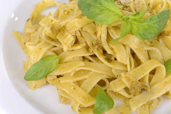 Läckra pasta med pesto på tallriken på bordet närbild — Stockfoto